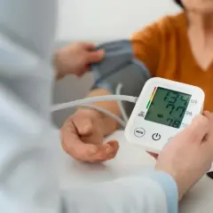 Lekarz mierzy ciśnienie pacjentowi, monitorując potencjalne objawy nadciśnienia. Wynik 134/77 mmHg.
