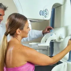 Lekarz nadzoruje badanie mammograficzne pacjentki.