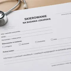 Dokument "Skierowanie na badania lekarskie" z pieczątką, stetoskopem i długopisem.