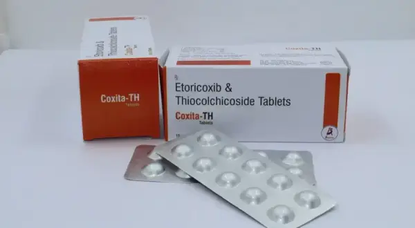 Dwie paczki i blistry leków Coxita-TH, zawierających etoricoxib i thiocolchicoside, gotowe do ulgi.