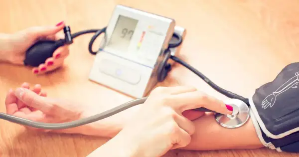 Dwie osoby mierzą ciśnienie. Jedna ręka trzyma pompkę, druga stetoskop. Na ekranie ciśnieniomierza widnieje wynik 97. To ważny pomiar dla zdrowia, jak ten z hygrotonem.